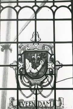 het wapen van Veendam. In de raadszaal van het gemeentehuis bevinden 16 gebrandschilderde ramen. Deze zijn vervaardigd door de bekende glazenier jan Schouten uit Delft. Hier zien we het huidige gemeentewapen van Veendam.